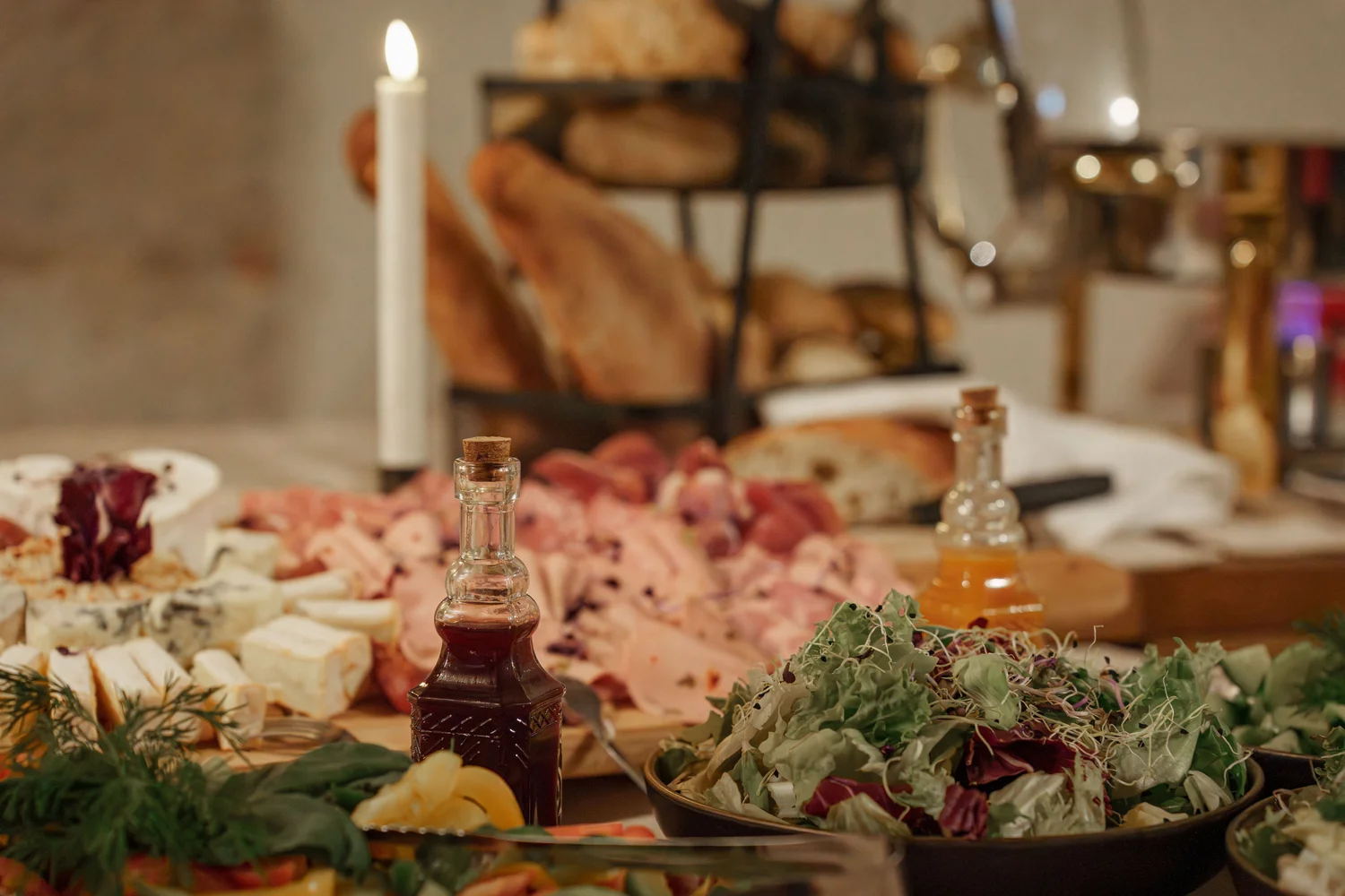 Königliche Schlossgastronomie – Das Bild zeigt ein Buffet mit einer Vielzahl von Gerichten, darunter warme Speisen in Warmhaltebehältern, frische Salate und eine Platte mit verschiedenen Fleisch- und Käsesorten.