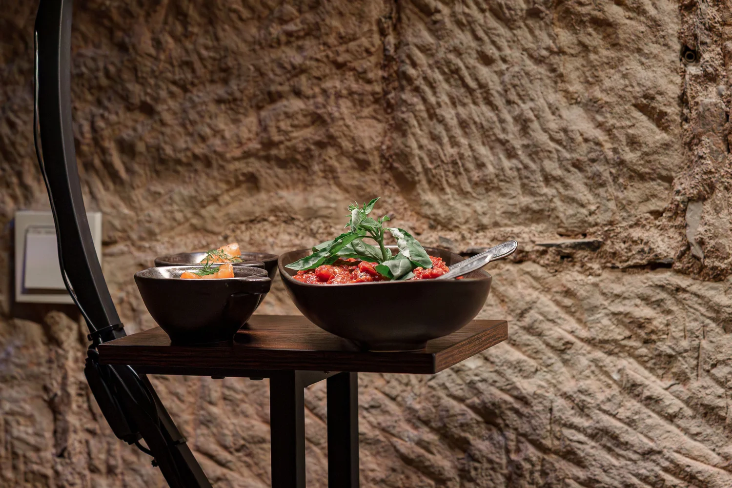 Königliche Schlossgastronomie – Hierbei handelt es sich offenbar um eine Portion Räucherlachs oder Lachstatar, präsentiert in einer kleinen, rustikalen dunklen Keramikschale, wahrscheinlich ein Gericht aus einem gehobenen Restaurant oder Café.